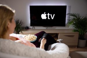 Woman watching apple television at home.