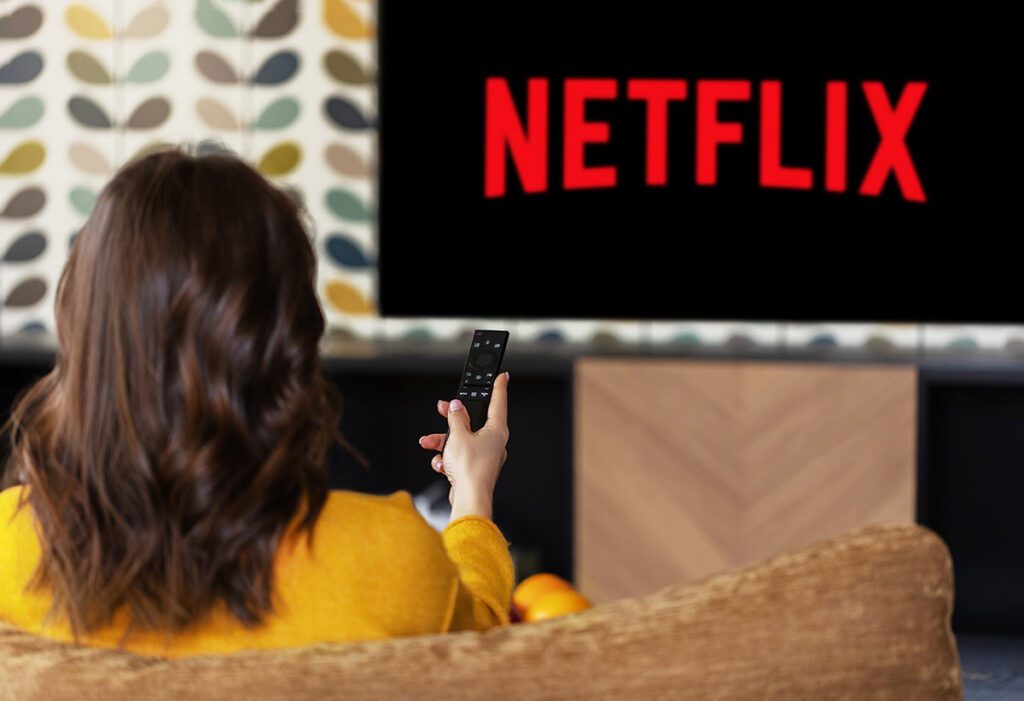 Woman watching netflix on big screen at home.