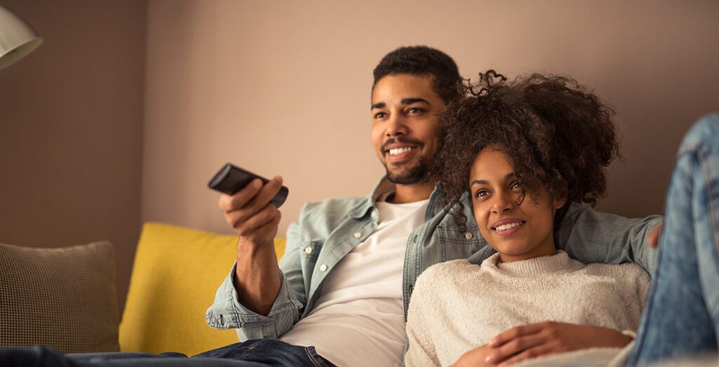 Couple at home watching tv together.